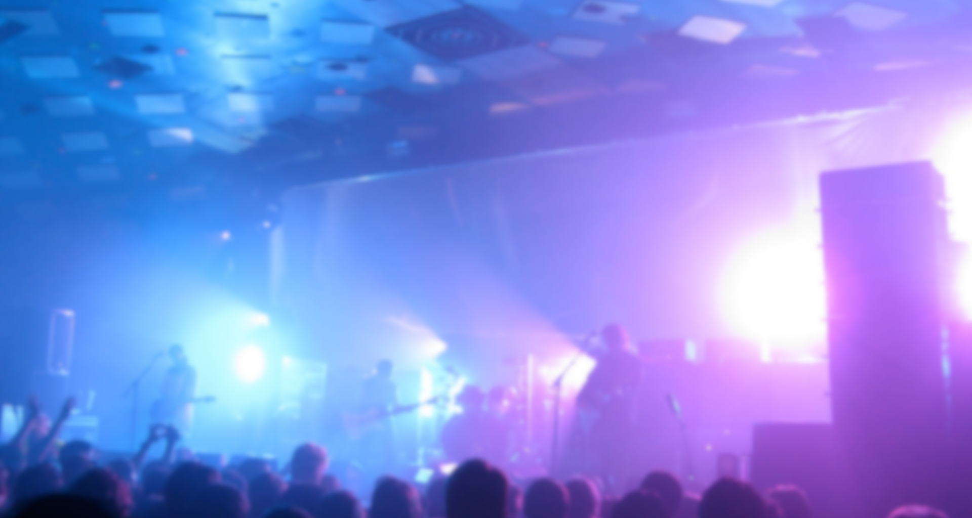 Photo of My Bloody Valentine on stage with purple lighting and fog machines