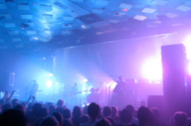 Photo of My Bloody Valentine on stage with purple lighting and fog machines