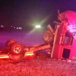 Image of wrecked truck / accident wreckage on grass at nighttime.