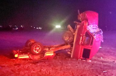 Image of wrecked truck / accident wreckage on grass at nighttime.