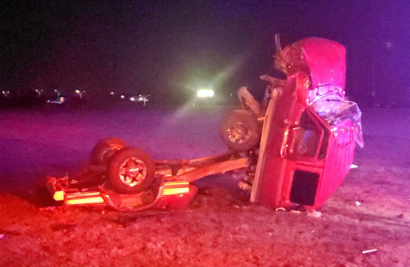 Image of wrecked truck / accident wreckage on grass at nighttime.