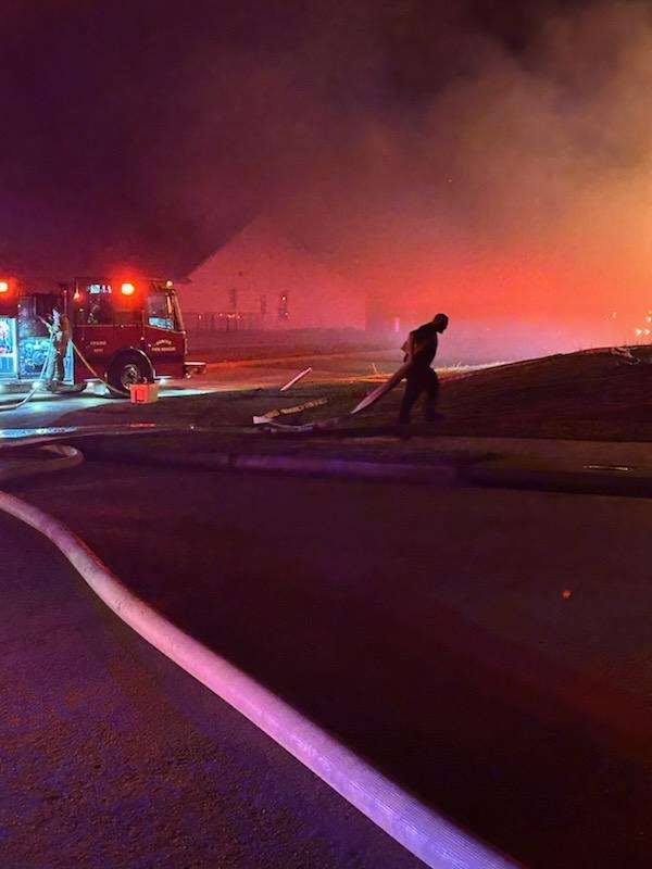 Firefighters responding to a house fire at night.